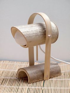 a wooden table lamp sitting on top of a bamboo mat