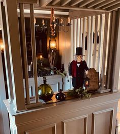 a doll is sitting on top of a mantle in a room with candles and decorations