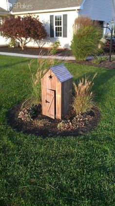 a small wooden box in the middle of some grass