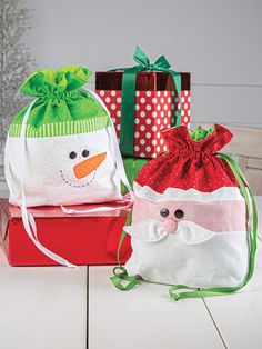 two bags with snowmen on them sitting next to each other in front of christmas presents