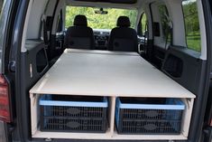 the back end of a van with two crates in it