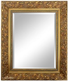 an ornate gold framed mirror with scrolls on it's sides and a white background