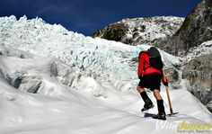 a man hiking up the side of a snow covered mountain