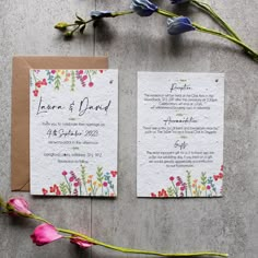 the wedding stationery is laid out next to some flowers