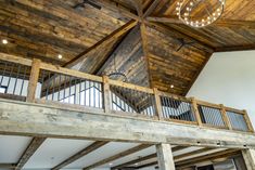 the inside of a house with wood beams and chandelier