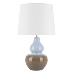 a blue and brown lamp with a white shade on the top is sitting in front of a white background