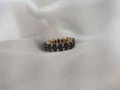 a black and gold ring sitting on top of a white cloth