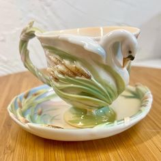 a white bird sitting on top of a saucer