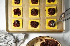 a pan filled with desserts on top of a counter next to a spatula