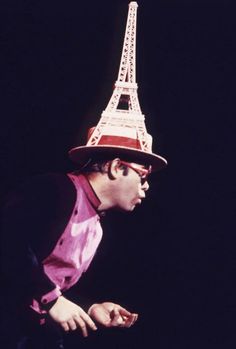 a man wearing a hat with the eiffel tower in the background