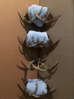 three deer antlers mounted to the side of a wall with blue towels on them