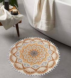 a bath tub sitting next to a rug on top of a floor in a bathroom