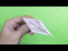 someone is holding an origami paper airplane