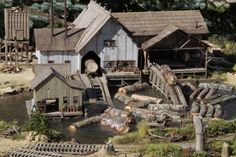 there are many logs in the water next to houses