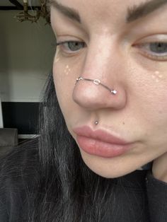 a woman with piercings on her nose looking at the camera