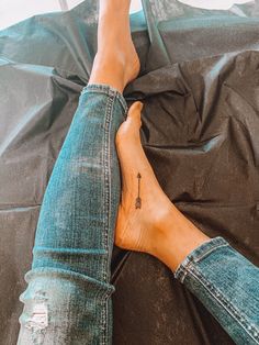 a woman's foot with a cross tattoo on it