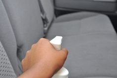 a person holding a remote control in their hand while sitting in a car with the steering wheel behind them