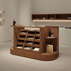 a wooden counter with bottles on it in a room that has white walls and flooring