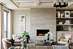 a living room filled with furniture and a fire place in the middle of it's wall