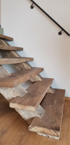 a set of stairs made out of wooden planks in a room with hard wood flooring