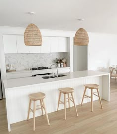 three stools sit in front of the kitchen counter