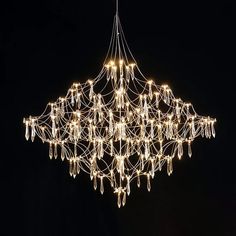 a large chandelier with lights hanging from it's sides in the dark