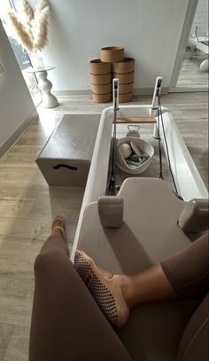 a woman's feet resting on the edge of a table in front of a sink