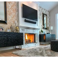 a living room filled with furniture and a flat screen tv mounted on the wall above a fireplace