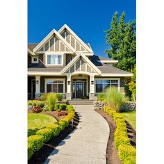 a large house with lots of landscaping in the front yard and walkway leading up to it