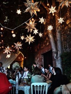 a group of people sitting at a table under stars hanging from the ceiling above them