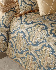 a blue and gold comforter with pillows on it