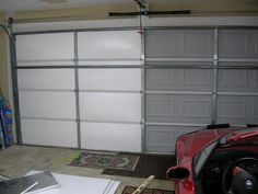 a garage with two cars parked in front of the garage door and another car sitting next to it