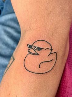 a tattoo on the arm of a person with a rubber ducky head and glasses