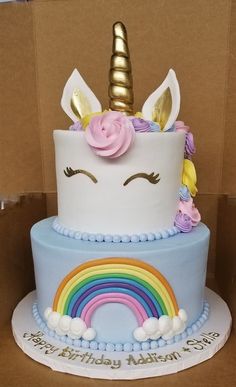 a birthday cake decorated with a unicorn's head and rainbow