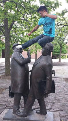 a man is balancing on the back of a statue