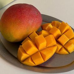 there is a mango and some pieces of fruit on the plate