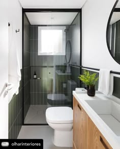 a white toilet sitting in a bathroom next to a wooden cabinet and sink under a mirror