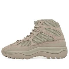 Be one step ahead of the trends this season with the new Adidas Yeezy Desert Boot. This unique, three-quarter boot borrows elements from the chunky Yeezy 500 and is perfect for a futuristic look. The upper features mesh with supple suede overlays, rope laces and an exaggerated mudguard. A thick foam midsole adds cushion, pairing with a rugged, outdoors-ready outsole. A sandy, military-type tone covers the silhouette, with just and embossed adidas logo on the bottom of the sole for branding. Rock Kanye West Adidas, Luxury Bag Brands, Yeezy Boots, Sneaker Trend, Yeezy 500, Desert Boot, Stylish Boots, Casual Athletic, Pharrell Williams