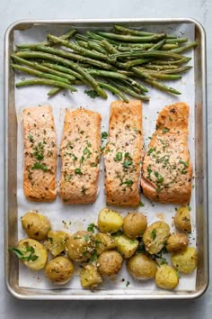 salmon, potatoes and asparagus on a baking sheet