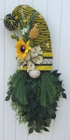 a yellow hat with sunflowers and greenery on the side of a building