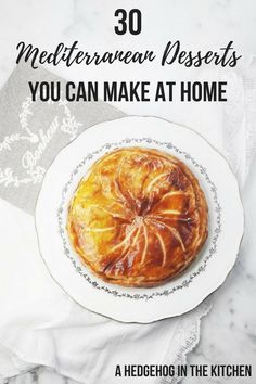 a white plate topped with a pastry on top of a table next to a napkin