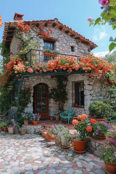 an old stone house with potted plants and flowers