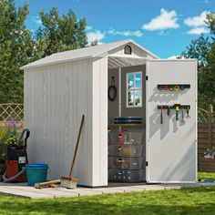 a white shed with tools on the outside