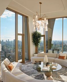 a living room filled with lots of furniture and large windows overlooking the cityscape