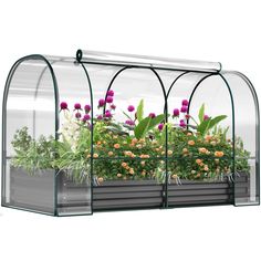 an indoor greenhouse with plants growing in the planter and flowers on the outside side