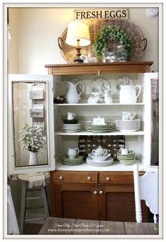 a white china cabinet with dishes on it