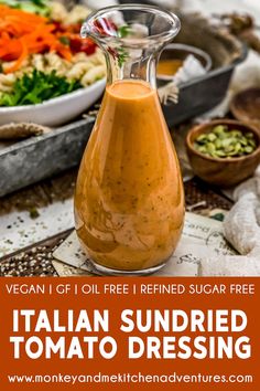 a glass bottle filled with sundried tomato dressing next to a bowl of salad