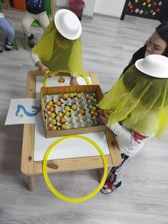 two women in yellow veils are preparing food on a table with bowls and plates