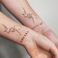 two people holding hands with tattoos on their arms that say love and peace in cursive writing