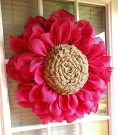 a large red flower hanging on the side of a window